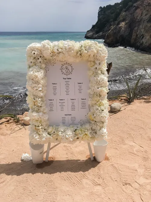 Tafelschikking in een lijst van witte bloemen op het strand